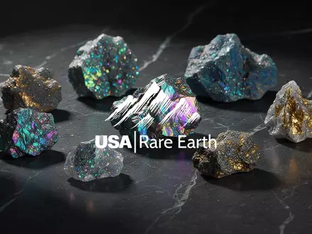 Nahaufnahme von glänzenden Seltenerdmineralien auf einer dunklen Oberfläche, die industrielle Wertschöpfung symbolisieren. - Foto: über boerse-global.de