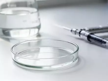 Ein sauberes, leeres Laborgefäß auf einem weißen Labortisch, das wissenschaftliche Forschung symbolisiert. - Foto: über boerse-global.de
