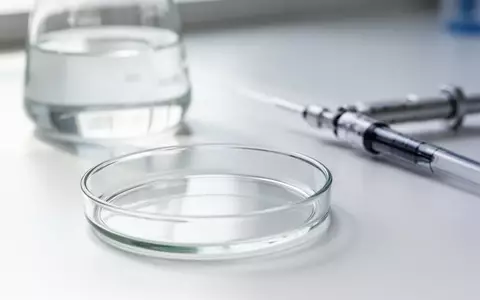 Ein sauberes, leeres Laborgefäß auf einem weißen Labortisch, das wissenschaftliche Forschung symbolisiert. - Foto: über boerse-global.de