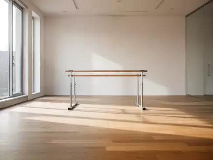 Ein minimalistischer, lichtdurchfluteter Trainingsraum mit Holzboden und einer Trainingsstange im Hintergrund. - Foto: über boerse-global.de
