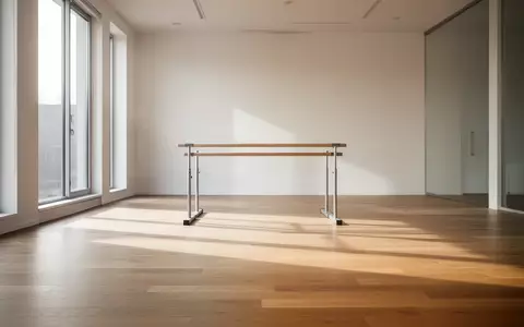 Ein minimalistischer, lichtdurchfluteter Trainingsraum mit Holzboden und einer Trainingsstange im Hintergrund. - Foto: über boerse-global.de