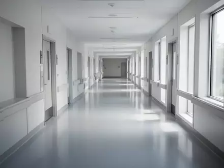 Ein leerer, modern gestalteter Krankenhausflur mit einfallendem Tageslicht und minimalistischer Architektur. - Foto: über boerse-global.de