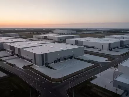 Weitläufiges, modernes Logistikareal mit großen, minimalistischen Lagerhallen in einer ruhigen Industrielandschaft. - Foto: über boerse-global.de