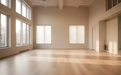 Ein heller, minimalistischer Übungsraum mit Holzboden und großen Fenstern, die natürliches Licht hereinlassen. - Foto: über boerse-global.de