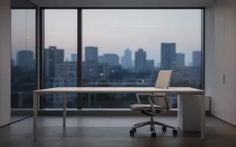 Ein minimalistischer, leerer Büroraum in der Dämmerung mit einem aufgeräumten Schreibtisch und einem ergonomischen Stuhl. - Foto: über boerse-global.de