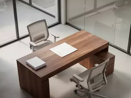 Ein minimalistischer, leerer moderner Büroraum mit einem Holztisch und natürlichem Licht, der eine professionelle Arbeitsumgebung symbolisiert. - Foto: über boerse-global.de