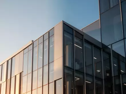 Moderne Glas- und Stahlfassade eines Bürogebäudes bei Tageslicht. - Foto: über boerse-global.de