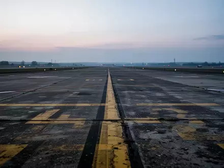 Leeres Rollfeld auf einem deutschen Regionalflughafen in der Abenddämmerung mit Bodenmarkierungen. - Foto: über boerse-global.de