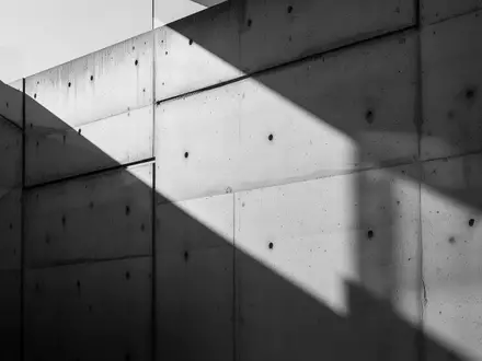 Abstrakte Architekturansicht einer modernen Betonfassade mit markanten Schattenwürfen. - Foto: über boerse-global.de