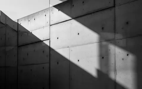 Abstrakte Architekturansicht einer modernen Betonfassade mit markanten Schattenwürfen. - Foto: über boerse-global.de