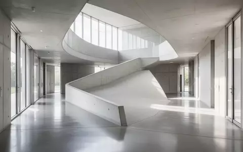 Eine helle, minimalistische Architektur mit einer barrierefreien Rampe in einem modernen Flur. - Foto: über boerse-global.de