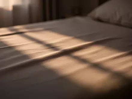 Ein minimalistisches, in sanftes Licht getauchtes Schlafzimmer mit Fokus auf Texturen und Lichtstimmung. - Foto: über boerse-global.de