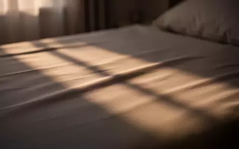 Ein minimalistisches, in sanftes Licht getauchtes Schlafzimmer mit Fokus auf Texturen und Lichtstimmung. - Foto: über boerse-global.de