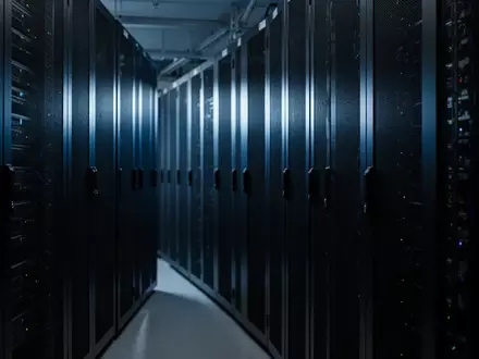 Dunkler, minimalistischer Serverraum mit symmetrischen Serverschränken in einer industriellen Umgebung. - Foto: über boerse-global.de