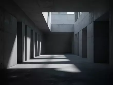 Ein minimalistischer, düsterer Betonkorridor mit geometrischen Schatten, der eine Atmosphäre von Isolation und industrieller Weite vermittelt. - Foto: über boerse-global.de