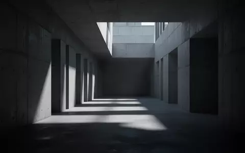 Ein minimalistischer, düsterer Betonkorridor mit geometrischen Schatten, der eine Atmosphäre von Isolation und industrieller Weite vermittelt. - Foto: über boerse-global.de