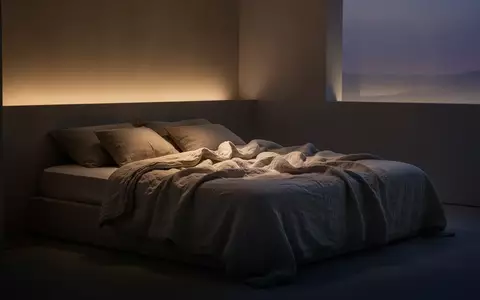 Ein minimalistisch eingerichtetes Schlafzimmer in der Dämmerung mit weicher Bettwäsche und sanfter Beleuchtung. - Foto: über boerse-global.de