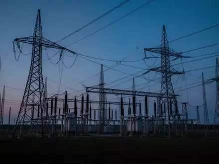 Hochspannungsmasten und elektrische Infrastruktur einer Transformatorenstation in der Dämmerung. - Foto: über boerse-global.de
