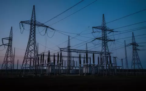 Hochspannungsmasten und elektrische Infrastruktur einer Transformatorenstation in der Dämmerung. - Foto: über boerse-global.de