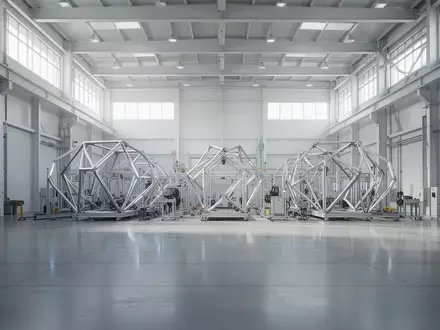 Eine leere, moderne Industriehalle mit hellen Betonböden und diffuser Beleuchtung, die eine technologische Umgebung andeutet. - Foto: über boerse-global.de