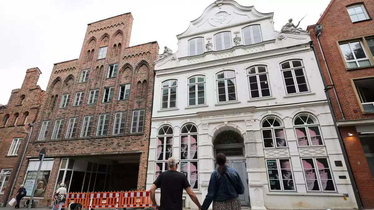 Passanten betrachten das geschlossene Buddenbrookhaus in der Lübecker Altstadt. - Bild: Christian Charisius/dpa