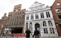 Passanten betrachten das geschlossene Buddenbrookhaus in der Lübecker Altstadt. - Foto: Christian Charisius/dpa