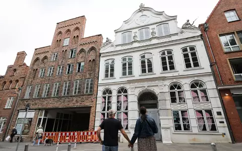 Passanten betrachten das geschlossene Buddenbrookhaus in der Lübecker Altstadt. - Foto: Christian Charisius/dpa