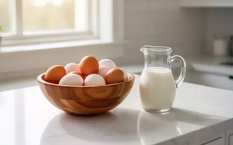 Eine Schale mit frischen Eiern und ein Glas Milch auf einer hellen Küchentheke im natürlichen Tageslicht. - Foto: über boerse-global.de