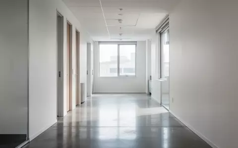 Ein heller, minimalistischer Büroflur mit poliertem Betonboden und weißer Wandgestaltung ohne Beschilderung. - Foto: über boerse-global.de