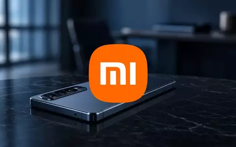 Modernes Smartphone auf einer dunklen, reflektierenden Oberfläche in einem minimalistischen Büro mit atmosphärischer Beleuchtung. - Foto: über boerse-global.de