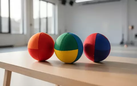 Drei bunte Jonglierbälle liegen auf einer hellen Holzoberfläche in einem minimalistischen, lichtdurchfluteten Raum. - Foto: über boerse-global.de