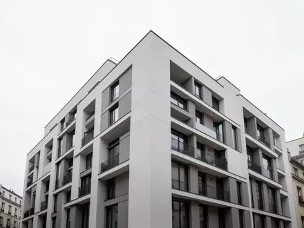 Ein minimalistisches, modernes Wohngebäude in einer ruhigen städtischen Umgebung bei bewölktem Himmel. - Foto: über boerse-global.de