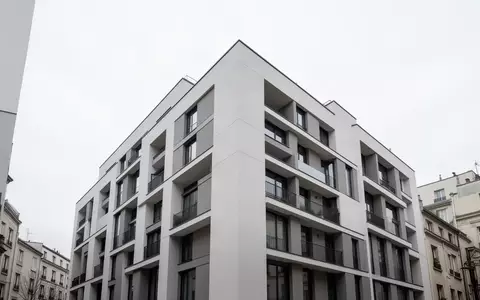 Ein minimalistisches, modernes Wohngebäude in einer ruhigen städtischen Umgebung bei bewölktem Himmel. - Foto: über boerse-global.de