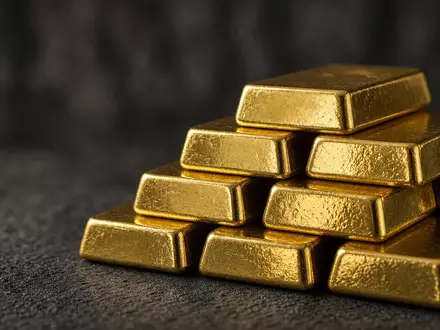 Gestapelte Goldbarren auf einer dunklen Oberfläche bei natürlichem, weichem Licht. - Foto: über boerse-global.de
