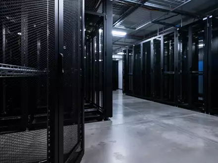 Ein dunkler, minimalistischer Serverraum mit leeren Serverschränken und kühler, bläulicher Beleuchtung. - Foto: über boerse-global.de
