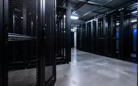 Ein dunkler, minimalistischer Serverraum mit leeren Serverschränken und kühler, bläulicher Beleuchtung. - Foto: über boerse-global.de