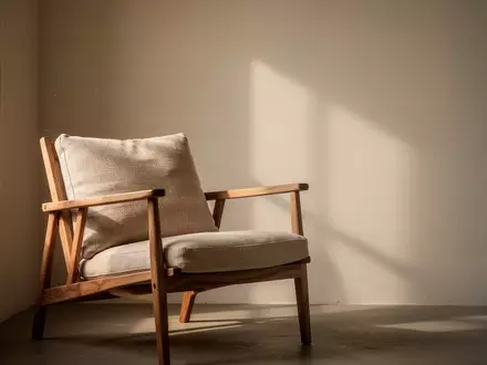 Ein ruhiger, minimalistischer Raum mit einem leeren Sessel in sanftem Tageslicht, der eine Atmosphäre der Kontemplation vermittelt. - Foto: über boerse-global.de