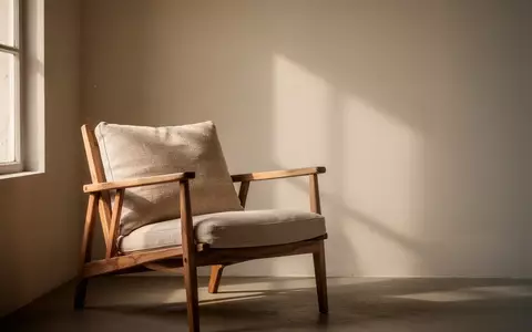 Ein ruhiger, minimalistischer Raum mit einem leeren Sessel in sanftem Tageslicht, der eine AtmosphĂ€re der Kontemplation vermittelt. - Foto: ĂŒber boerse-global.de