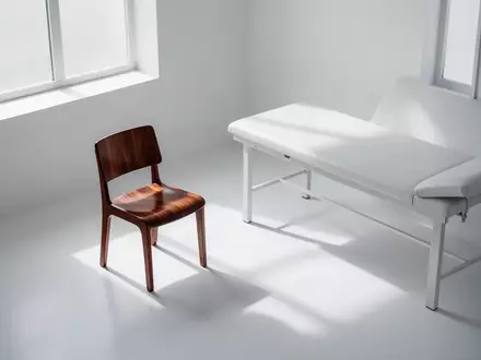 Ein minimalistischer, leerer Behandlungsraum in einer Arztpraxis mit Tageslichteinfall und klaren Schatten. - Foto: ĂĽber boerse-global.de
