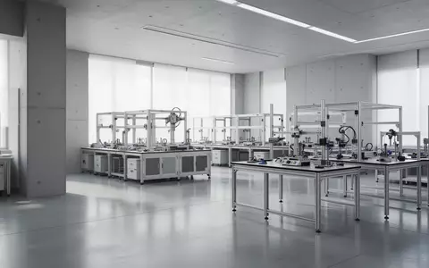 Ein minimalistisches, modernes Robotik-Forschungslabor mit polierten Betonböden und leeren Arbeitstischen in einem hellen Raum. - Foto: über boerse-global.de