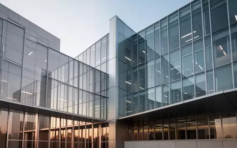 Moderne Glas- und Stahlfassade eines Verwaltungsgebäudes bei klarem Himmel. - Foto: über boerse-global.de