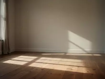 Ein minimalistischer Raum mit weichem, durch ein Fenster einfallendem Sonnenlicht auf einem Holzboden. - Foto: über boerse-global.de
