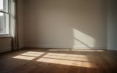Ein minimalistischer Raum mit weichem, durch ein Fenster einfallendem Sonnenlicht auf einem Holzboden. - Foto: ĂĽber boerse-global.de