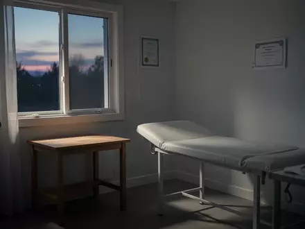 Ein minimalistisch eingerichtetes Behandlungszimmer in einem Privathaushalt bei Dämmerlicht. - Foto: über boerse-global.de
