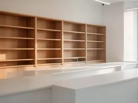 Ein minimalistischer Apothekenbereich mit leeren Holzregalen in hellem, natürlichem Licht. - Foto: über boerse-global.de
