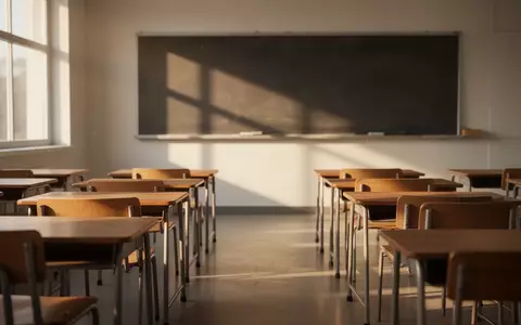 Ein leerer, sonnendurchfluteter Klassenraum mit leeren Schreibtischen in ordentlichen Reihen. - Foto: über boerse-global.de