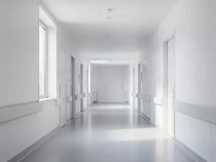 Ein heller, minimalistischer Krankenhausflur mit klaren Linien und natürlichem Lichteinfall ohne Personen oder Beschilderung. - Foto: über boerse-global.de