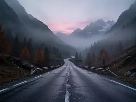 Eine neblige, einsame Bergstraße in den Alpen bei Dämmerung. - Foto: über boerse-global.de