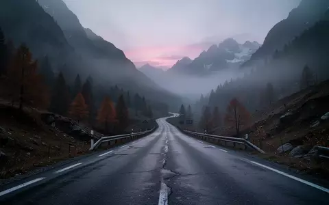 Eine neblige, einsame Bergstraße in den Alpen bei Dämmerung. - Foto: über boerse-global.de