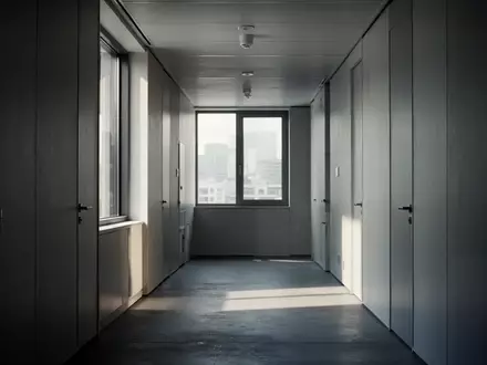 Ein leerer, minimalistisch gestalteter Flur in einem Bürogebäude mit ruhigem Lichteinfall. - Foto: über boerse-global.de